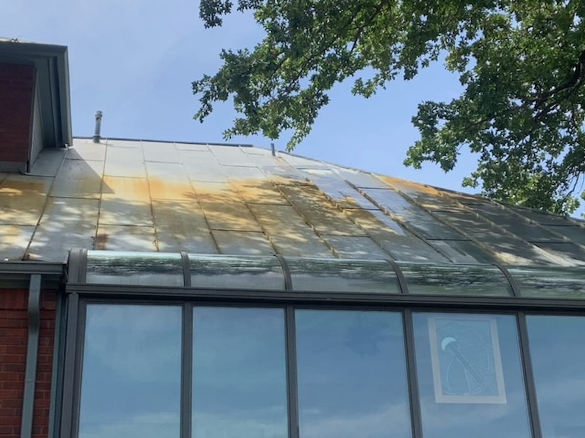 Metal roof with heavy pollen staining and organic buildup before roof cleaning in Corsicana Texas
