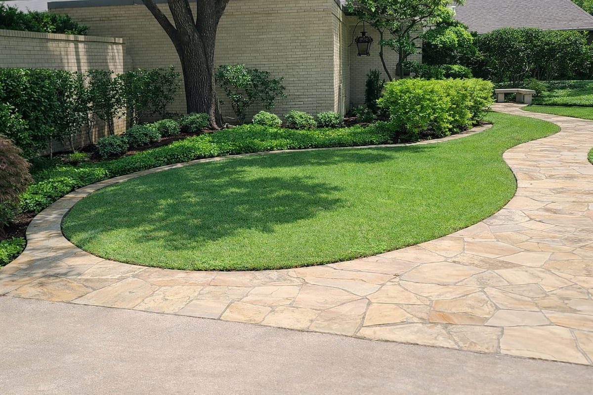 Sidewalk cleaning after pressure washing in Corsicana TX showing clean stone walkway surface