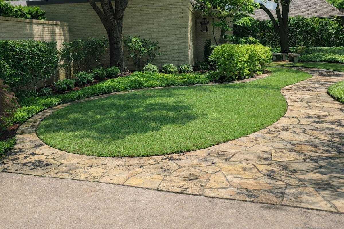 Sidewalk cleaning before pressure washing in Corsicana TX showing dirt algae and staining on stone walkway